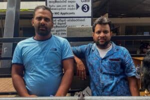 3x2With an economy in crisis Sri Lankans migrate out for jobs Two men wait outside a passport office in Sri Lanka.