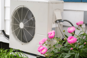 Heat pumps (900 x 600 px) Flowers grow next to a heat pump installed at a house.