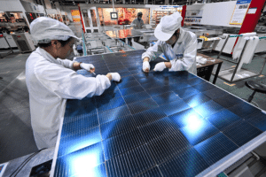 Tariffs and green tech Two women work on the production line of solar panels
