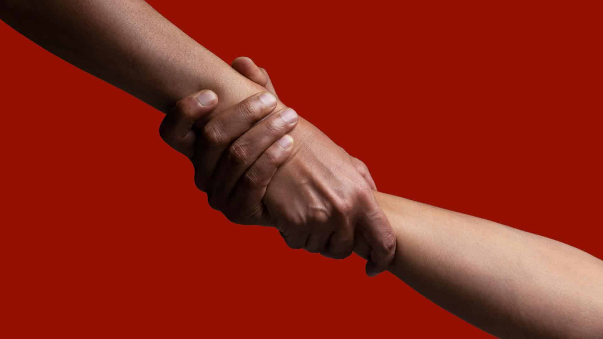 Two hands grasp each other