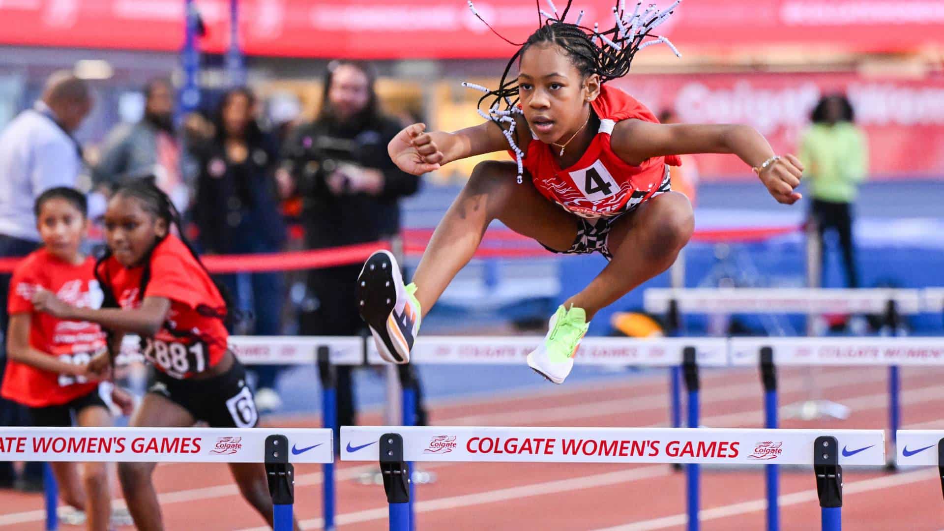 A young girl leaps over hurdles in a track meet at the 2025 Colgate Women's Games. 