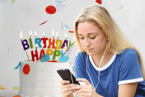 Social media ban A teen on her phone ignores a birthday cake.