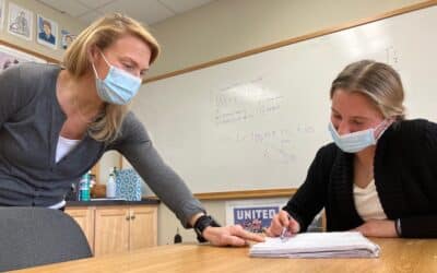 Masked and distanced, Lindsay McConnel helps a high-school student at the Tatnall School.