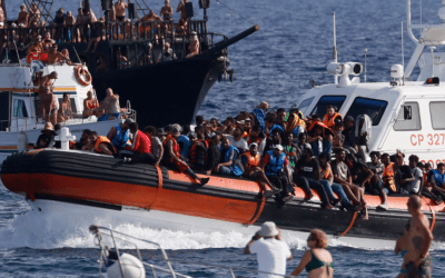 An Italian Coast Guard boat carries migrants as tourists on boat, foreground, watch, near the port of the Sicilian island of Lampedusa, southern Italy.