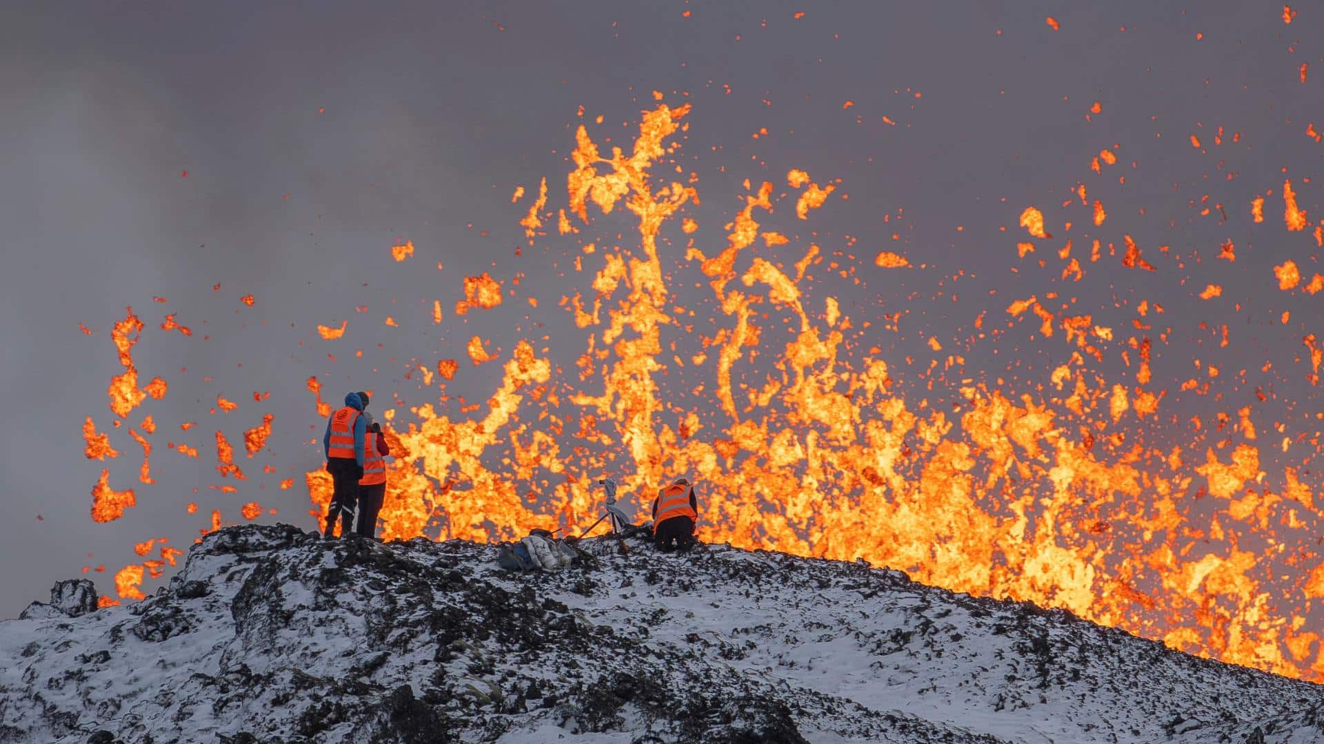Two scientist stand on the ridge of a volcano in Iceland
