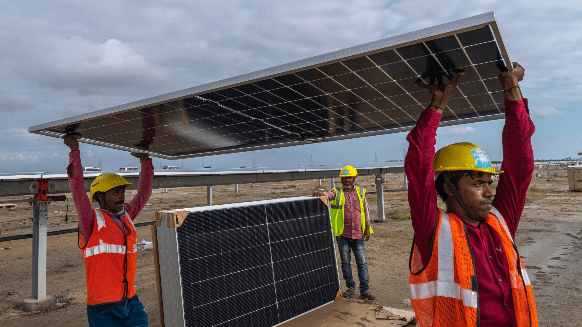 Workers carry a solar panel for installation