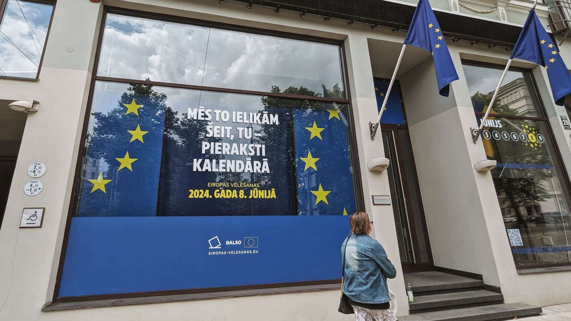 Wh Y vote Latvia (1) A woman walks by the European Union House in Riga, Latvia.