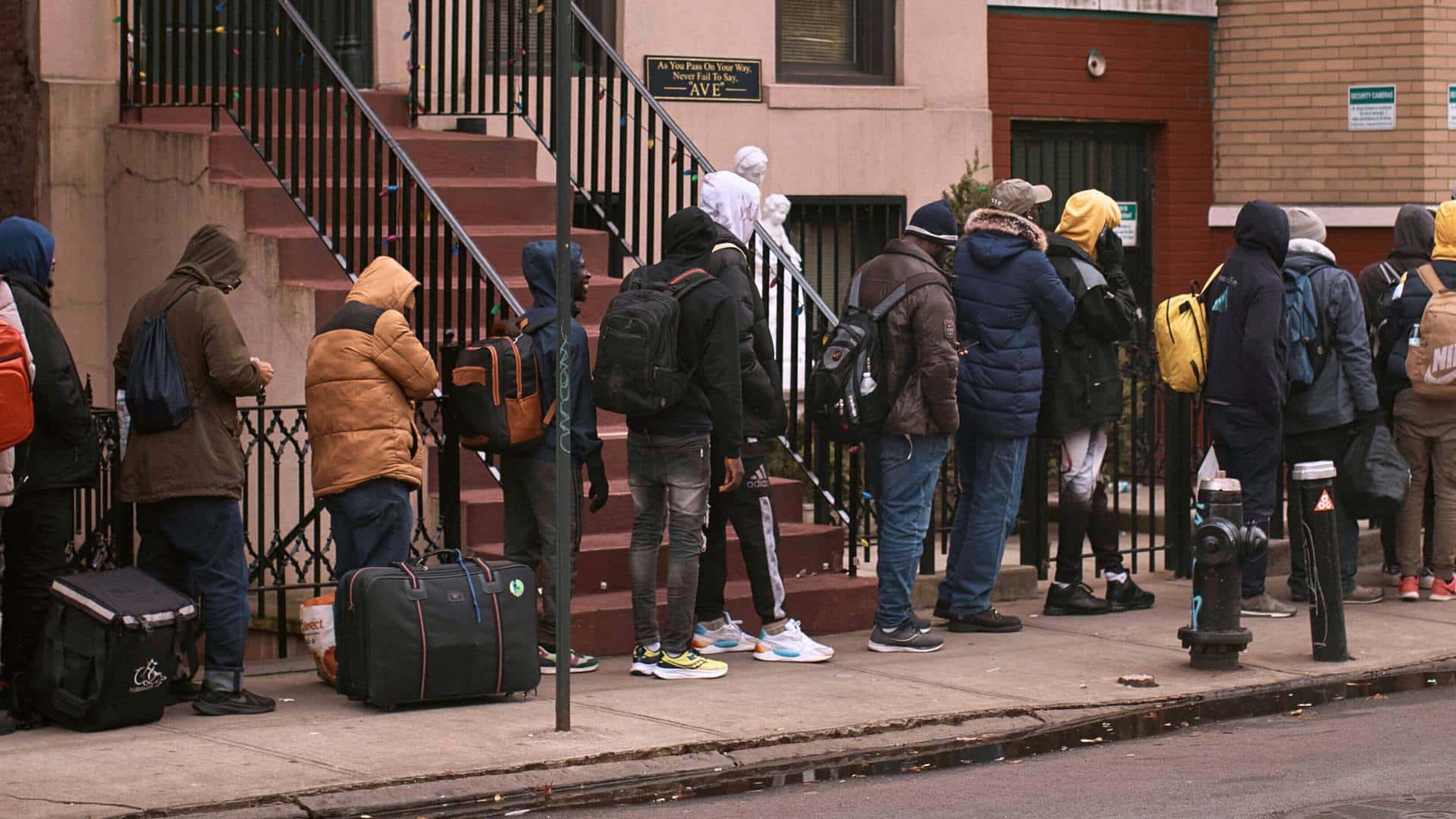 Migrants queue in the cold as they look for a shelter outside a migrant assistance center