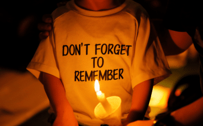A girl lights a candle at a protest.