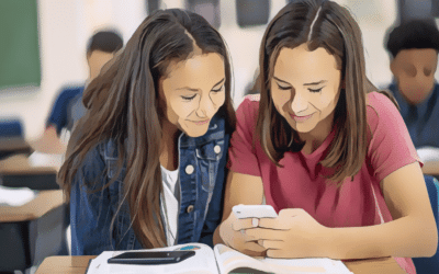 Two girls look at a phone in a class