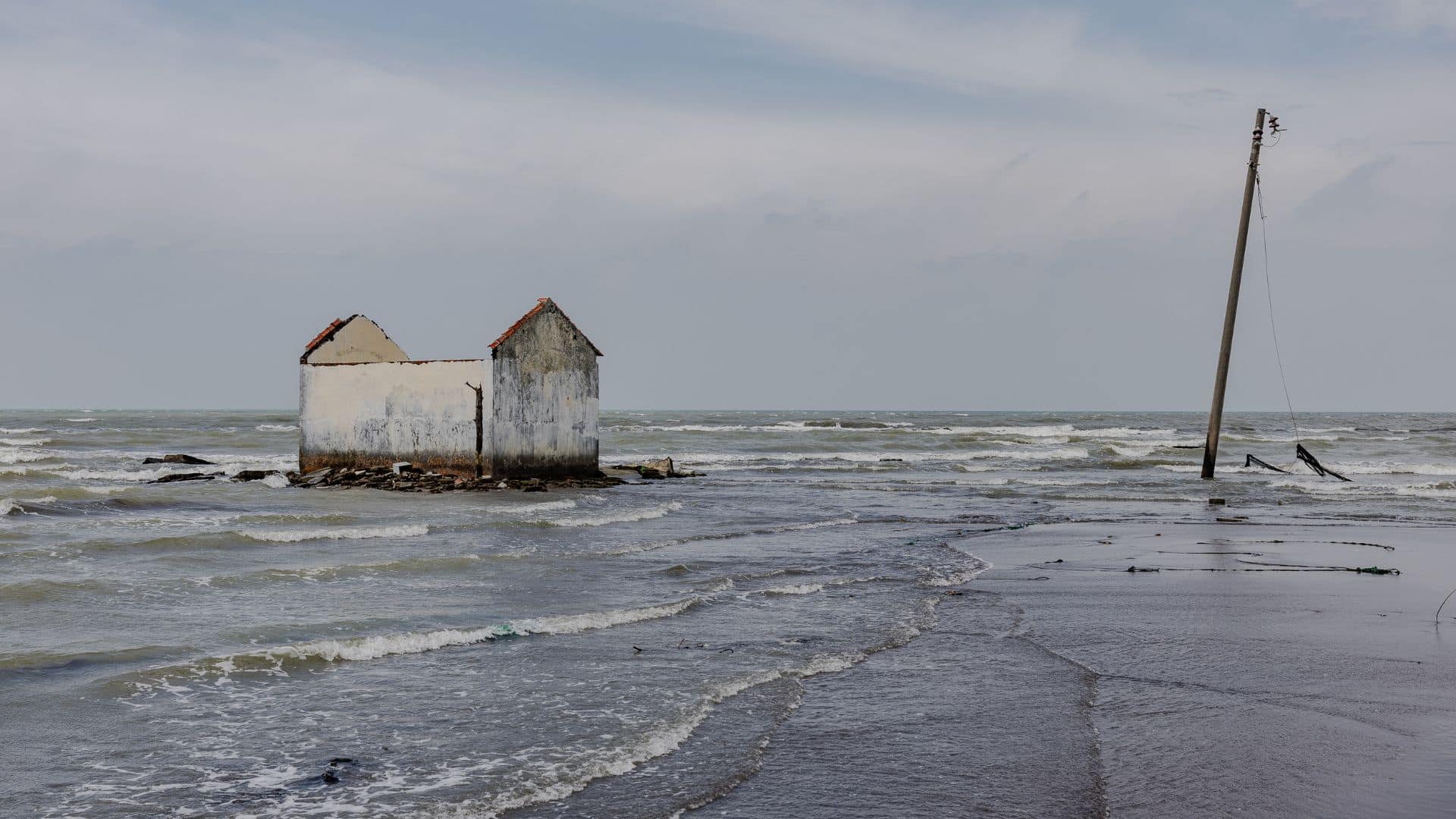 The remains of a house surrounded by the sea.